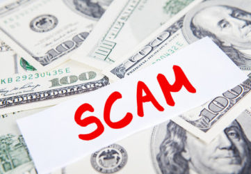 Scam concept: Money dollar bills with scam text